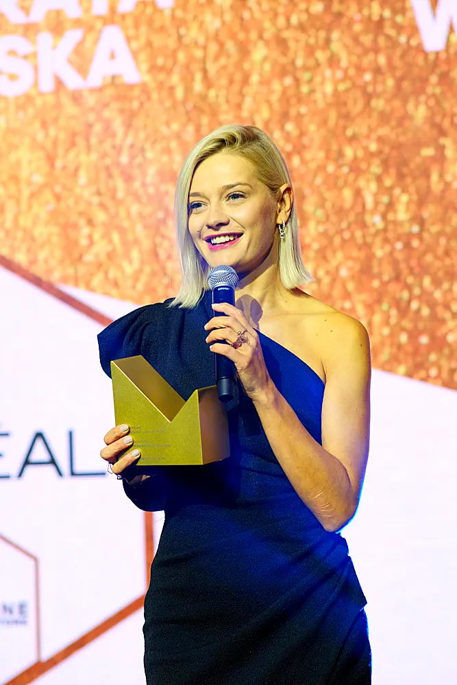 A smiling winner with her statuette