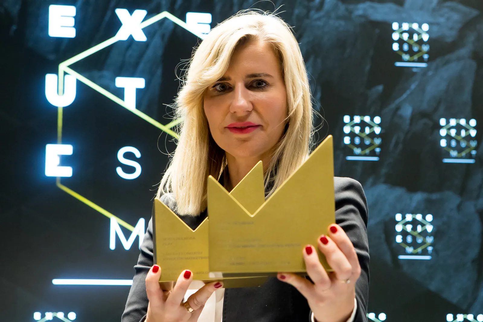 A winner holding two gold statuettes
