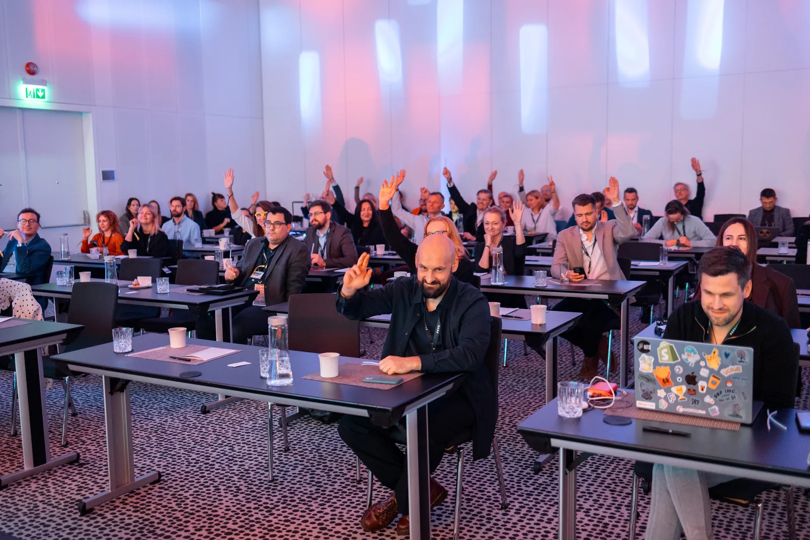Executive Summit attendees raising their hands