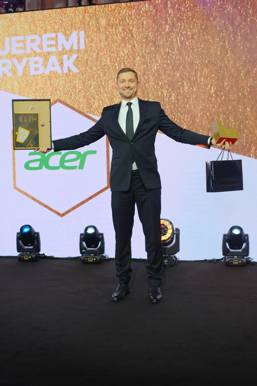 A winner with a diploma and statuette celebrating on the Gala stage