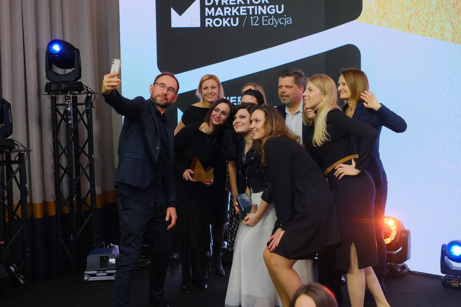 A marketing team with statuettes on stage